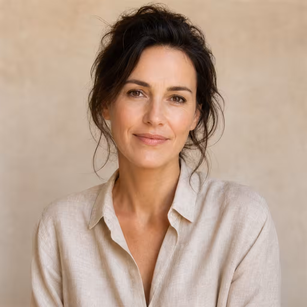 Femme souriante portant une chemise beige.